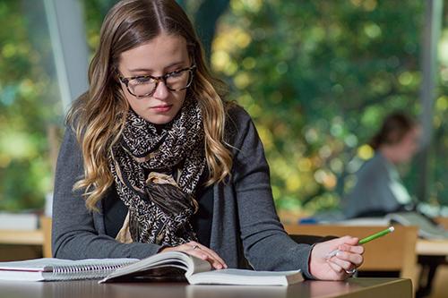 student at desk with book